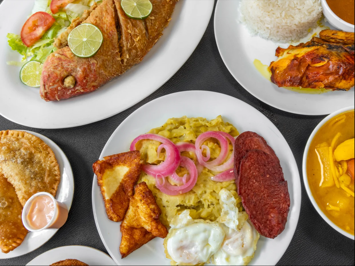 KOMEME AHORA featured image Assorted plates including fried fish, rice, and patties at KOMEME AHORA, Wakefield.