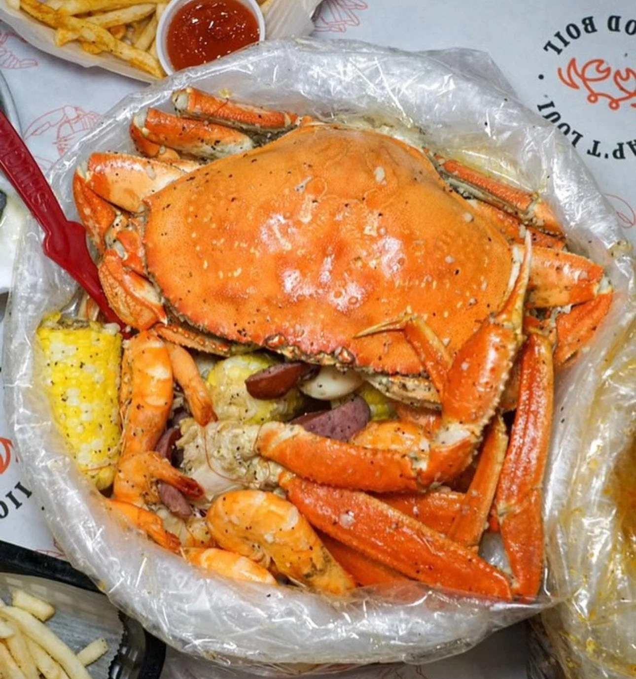 Crab, shrimp, sausage, and corn in a plastic bag at Cap't Loui, Ozone Park.