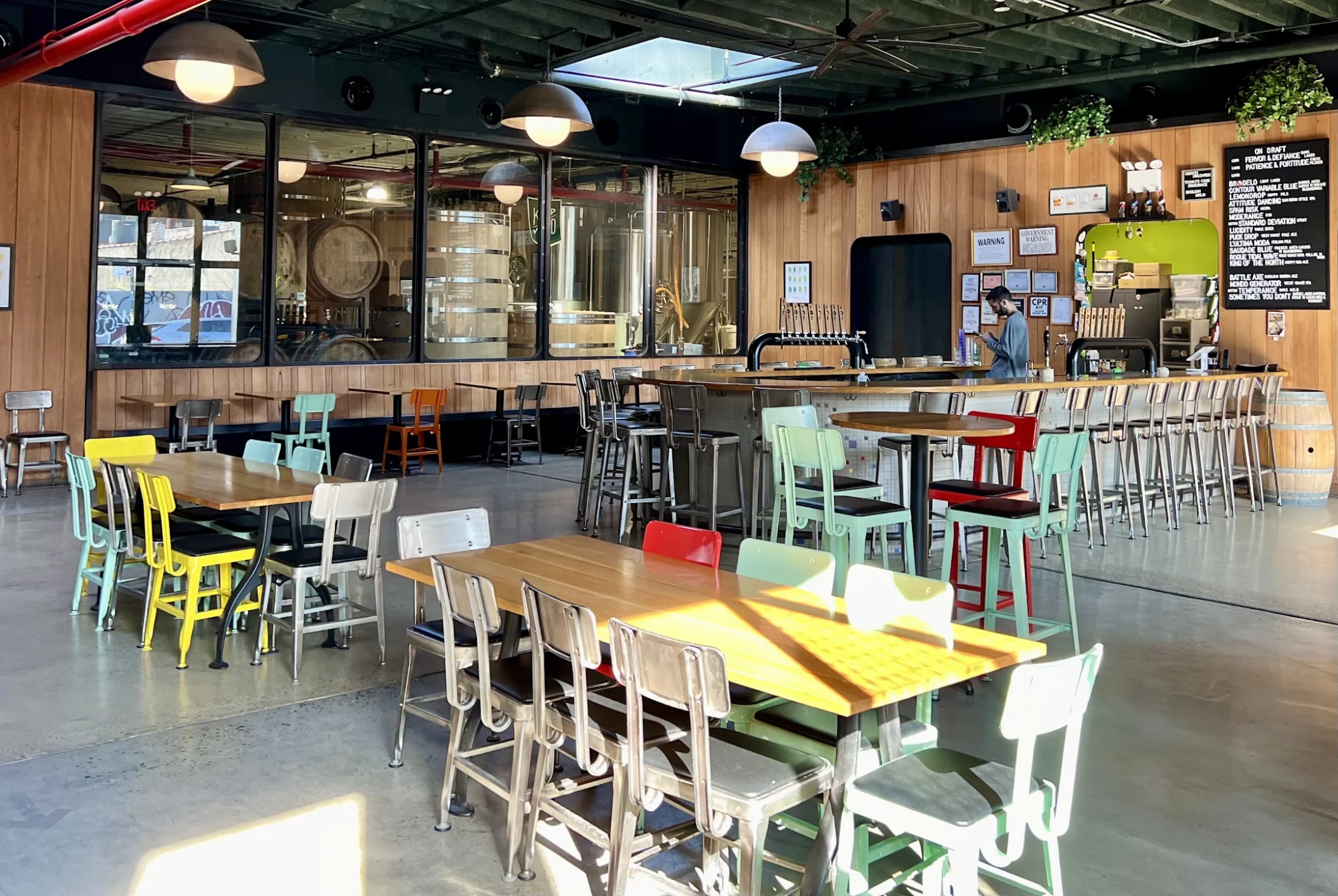 Wild East Brewing Co. featured image Interior of Wild East Brewing Co., Gowanus, Bronx NYC with tables and brewing tanks.