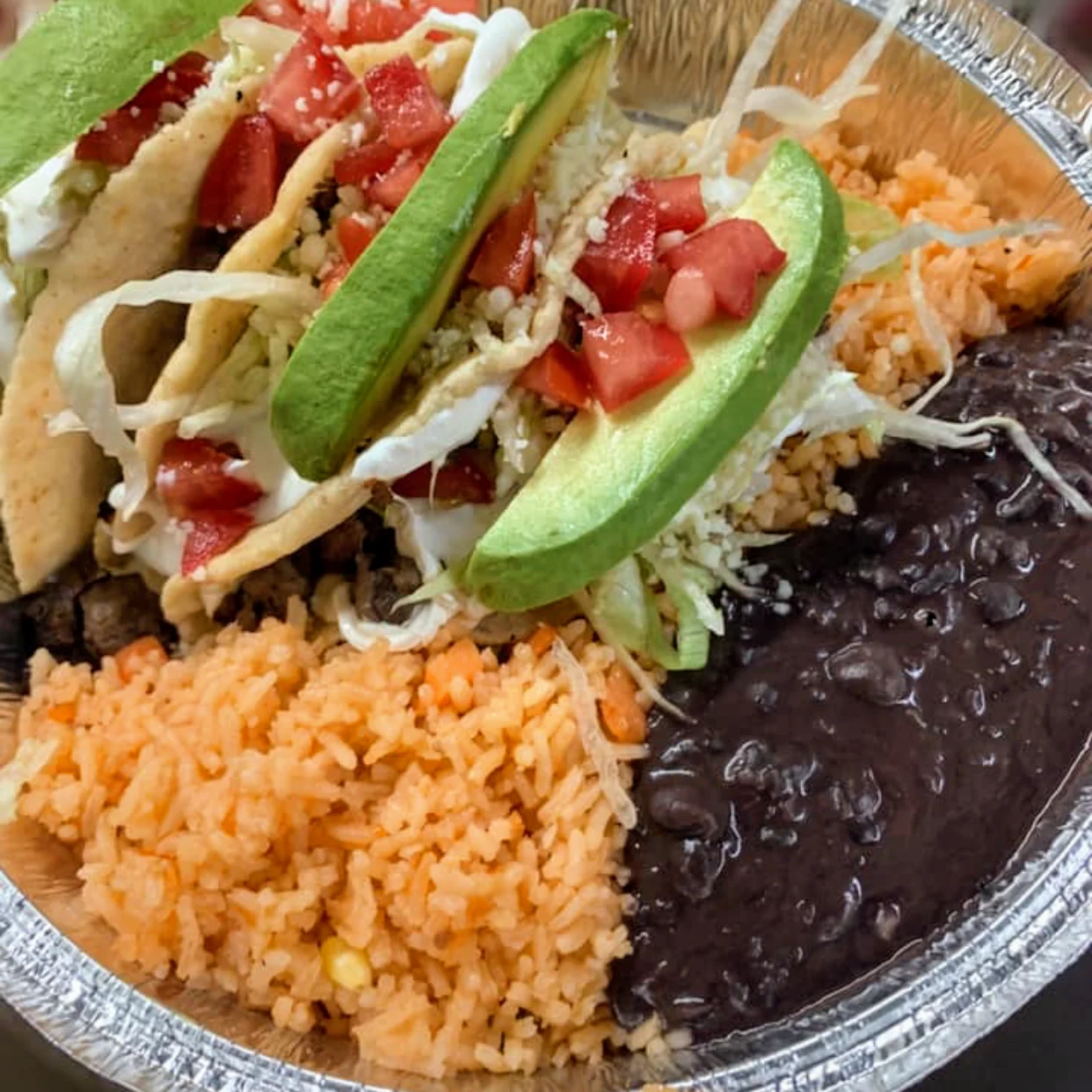 Plate with tacos, avocado slices, rice, and beans at Comercial Mexicana, Soundview Bronx NYC.
