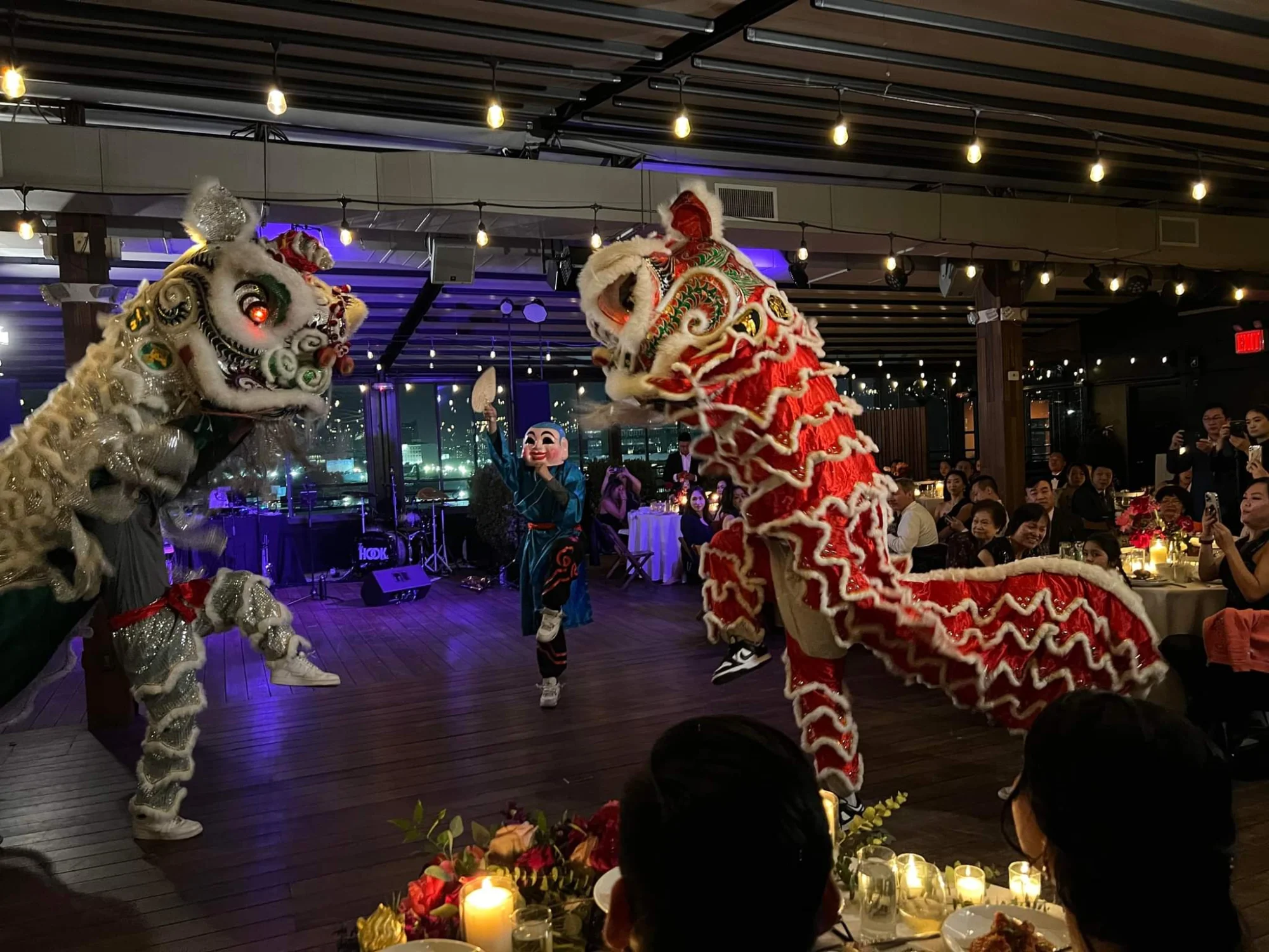Interior with lion dance performers and audience at Chinese Freemasons Athletic Club, Chinatown, Bronx NYC.