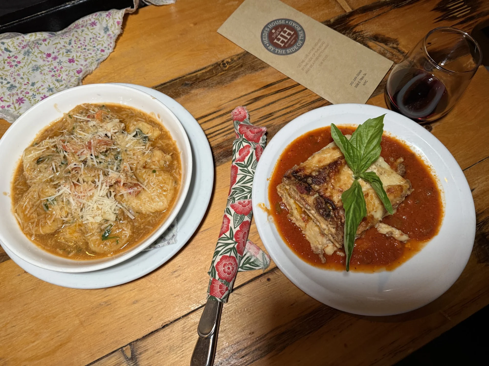Two plates of pasta dishes on a wooden table at Heidi's House, Upper East Side, Bronx NYC.
