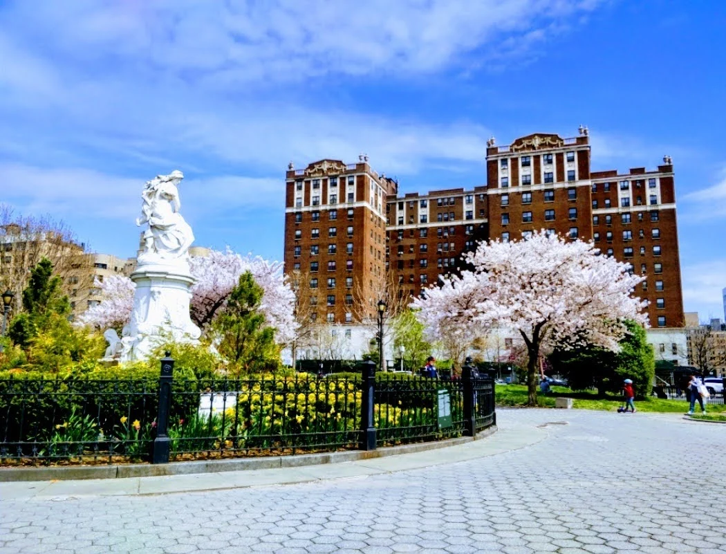 Grand Concourse Historic District featured image Grand Concourse Historic District with a statue, blooming cherry trees, and a historic building in Concourse, Bronx.