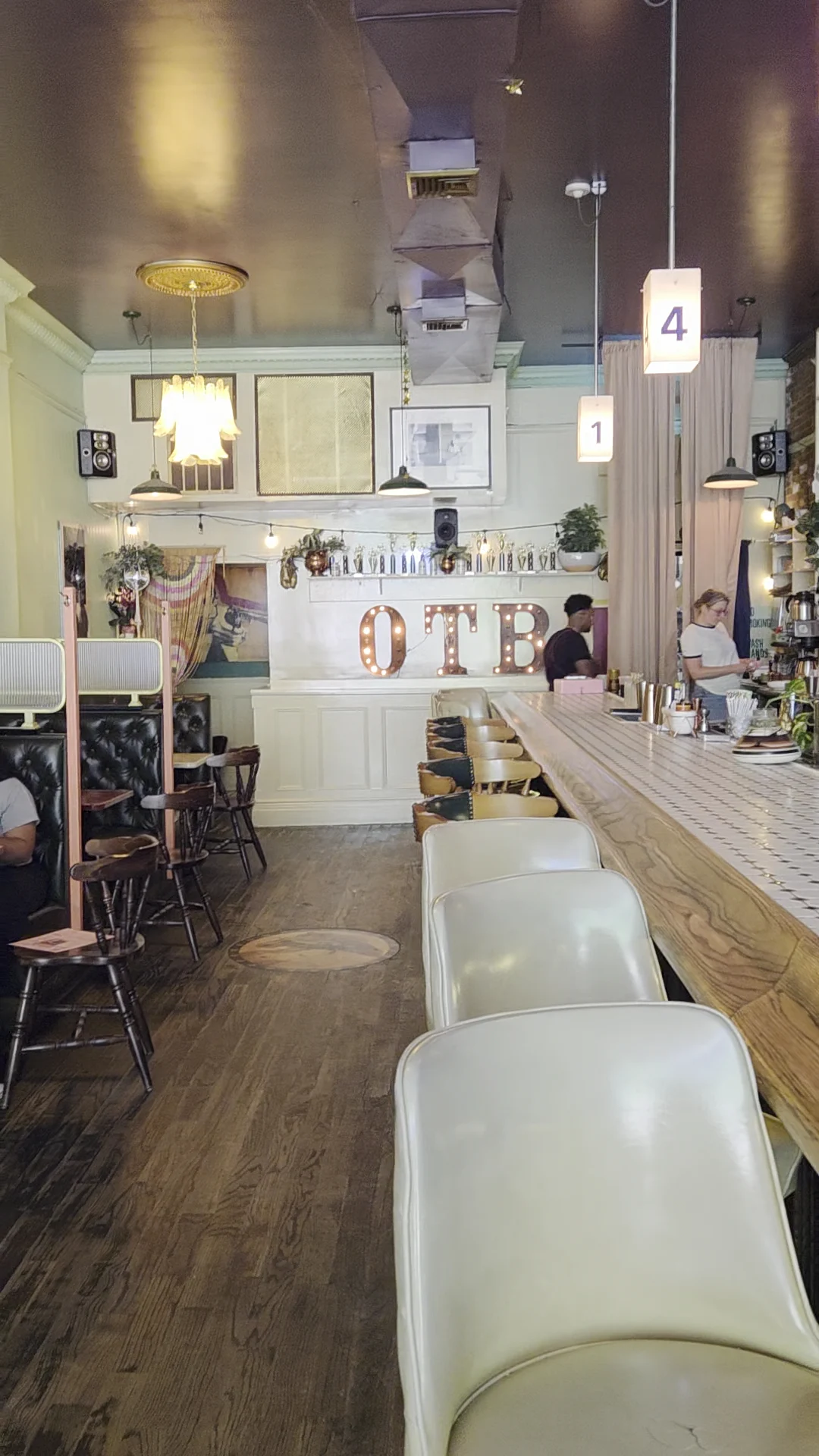 Interior of OTB, Williamsburg, with a long bar, chairs, and 'OTB' sign on the wall.