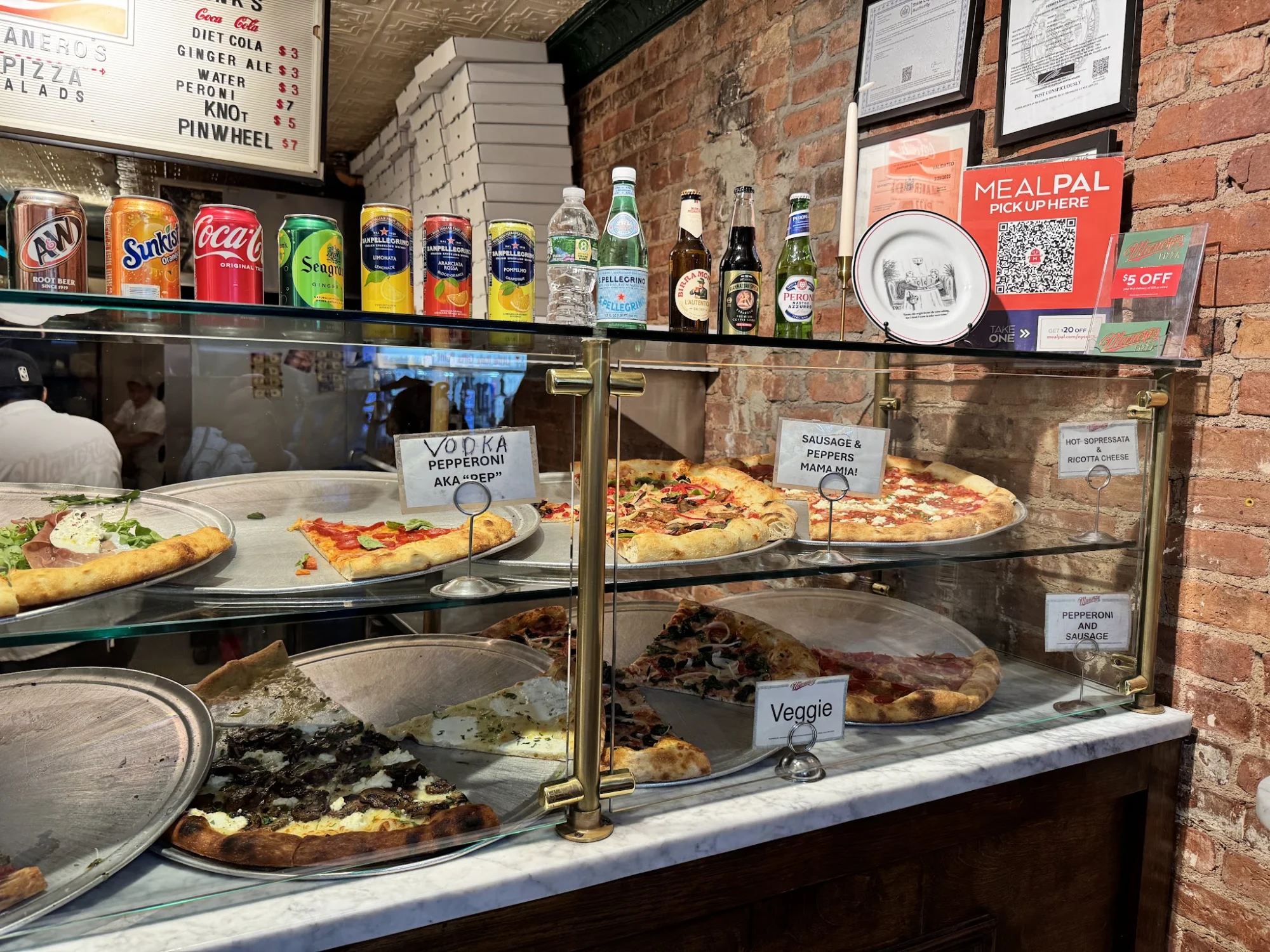 Manero's of Mulberry featured image Interior view of a pizza display at Manero's of Mulberry, Little Italy with various pizza options behind glass.